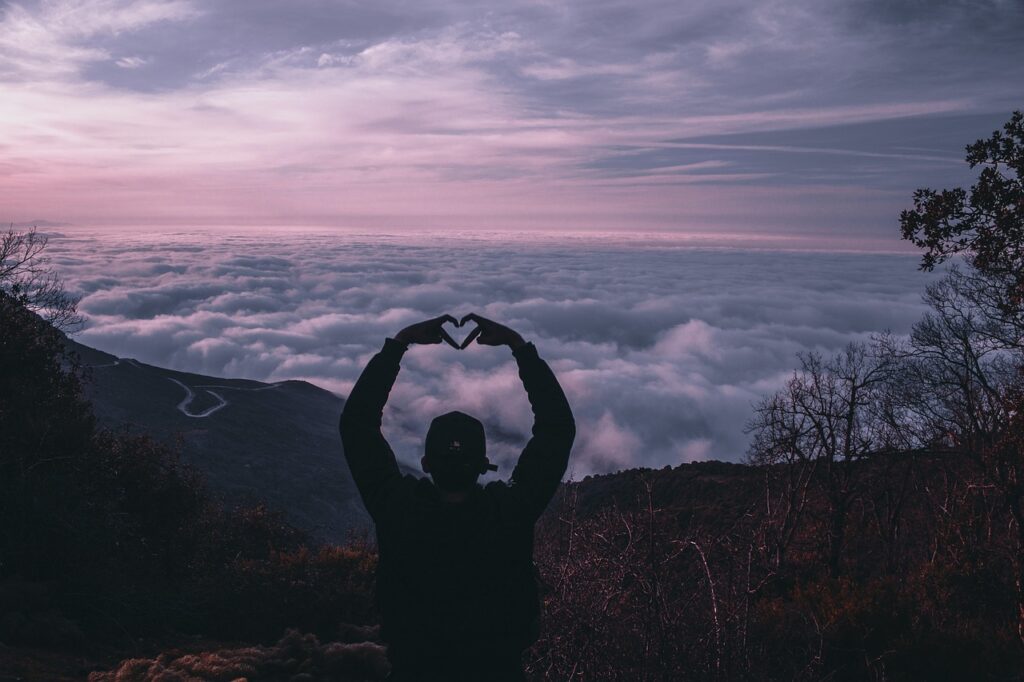 Man throwing love symbol at mountains